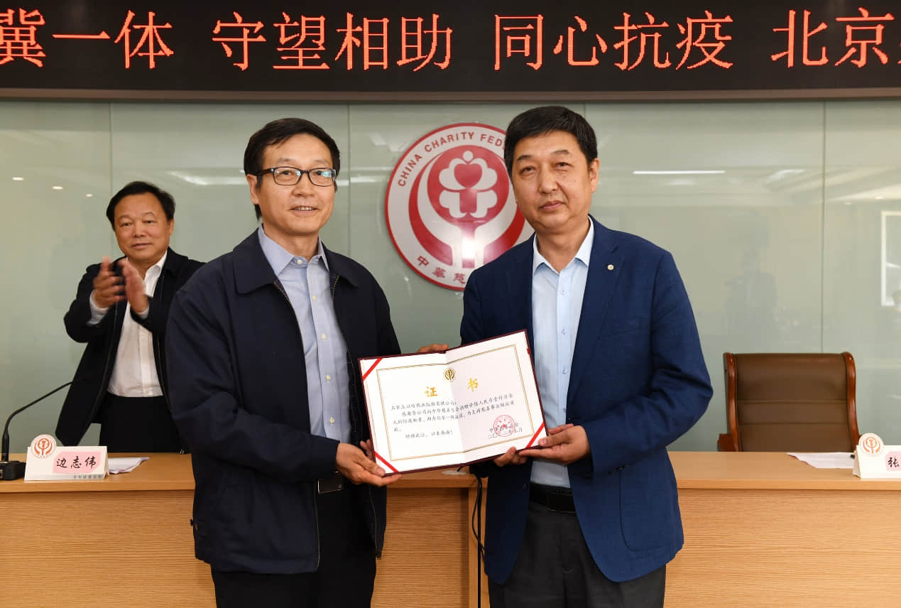 中华慈善总会党委书记、副会长孙达（左）向企业代表颁发捐赠证书。（李济慈摄）