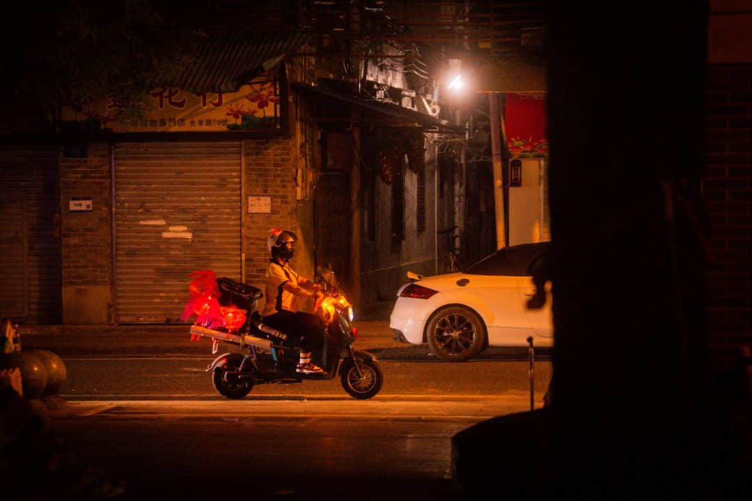 夜晚街道上骑摩托车的人

描述已自动生成