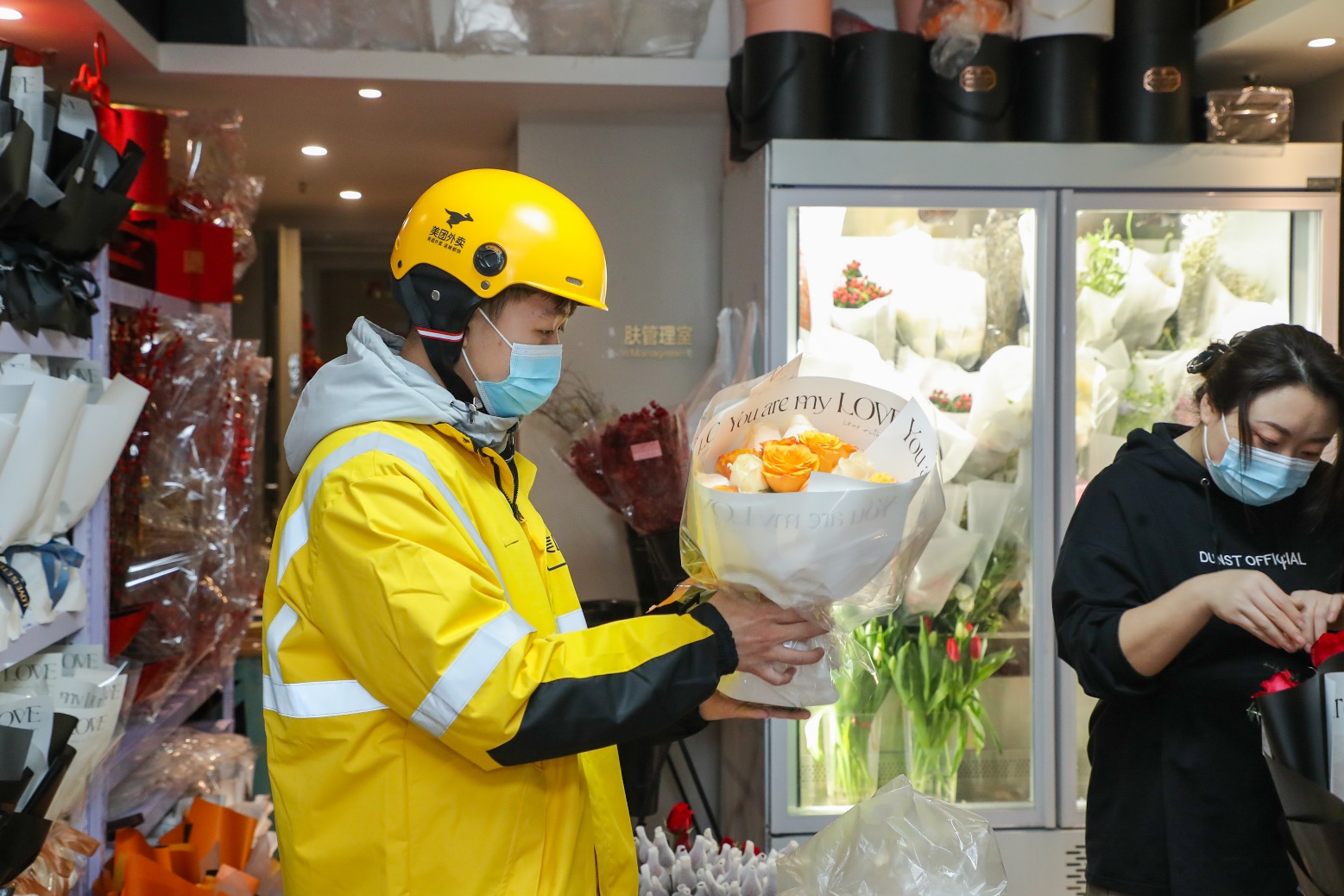 ▲情人节期间，外卖员在花店取鲜花订单。（摄影：李鸣）